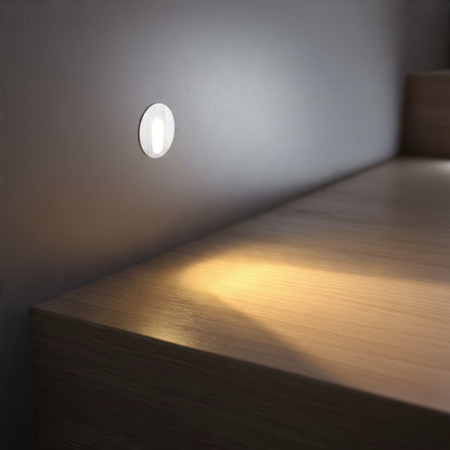 Ultra Beam Lighting Ltd round 1 watt recessed LED step light in brushed aluminium illuminating a wooden staircase