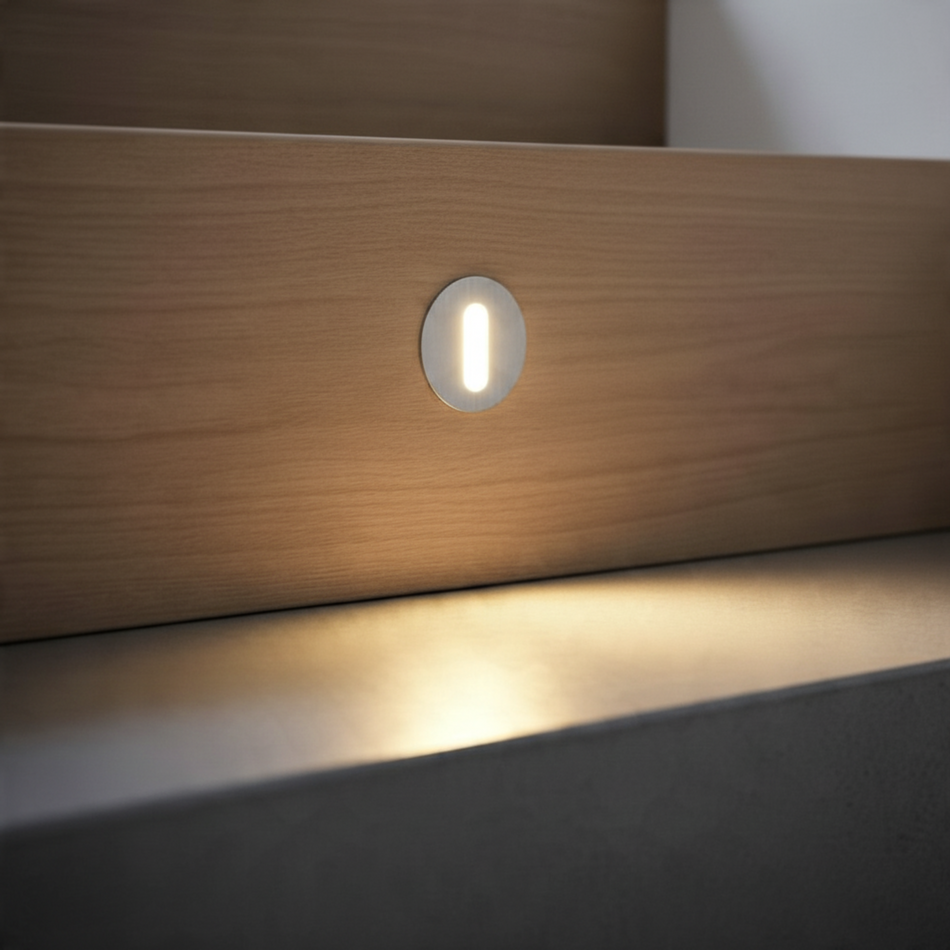 Ultra Beam Lighting Ltd round 1 watt recessed LED step light in brushed aluminium installed in a wooden staircase