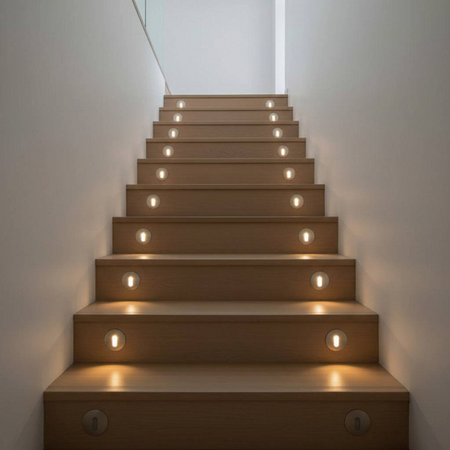 Ultra Beam Lighting Ltd round 1 watt recessed LED step lights installed on wooden staircase with warm glow