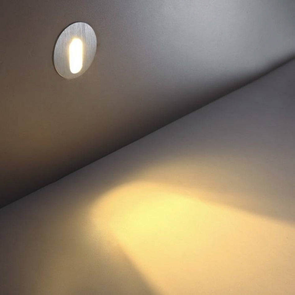 Ultra Beam Lighting Ltd round 1 watt recessed LED step light in brushed aluminium casting warm light on a wall