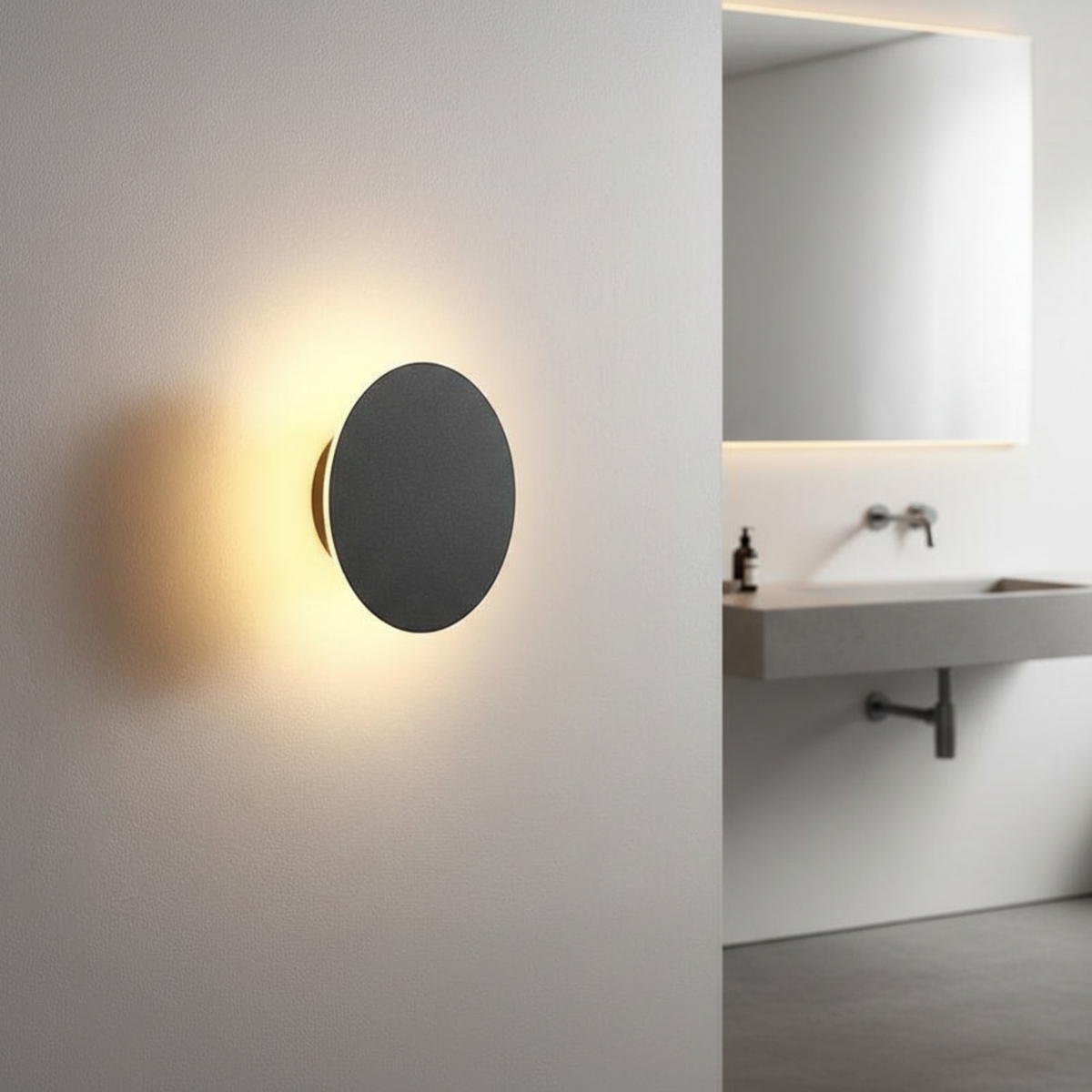 Ultra Beam Lighting Ltd round black bathroom sconce with warm 3000K LED light mounted on a modern bathroom wall
