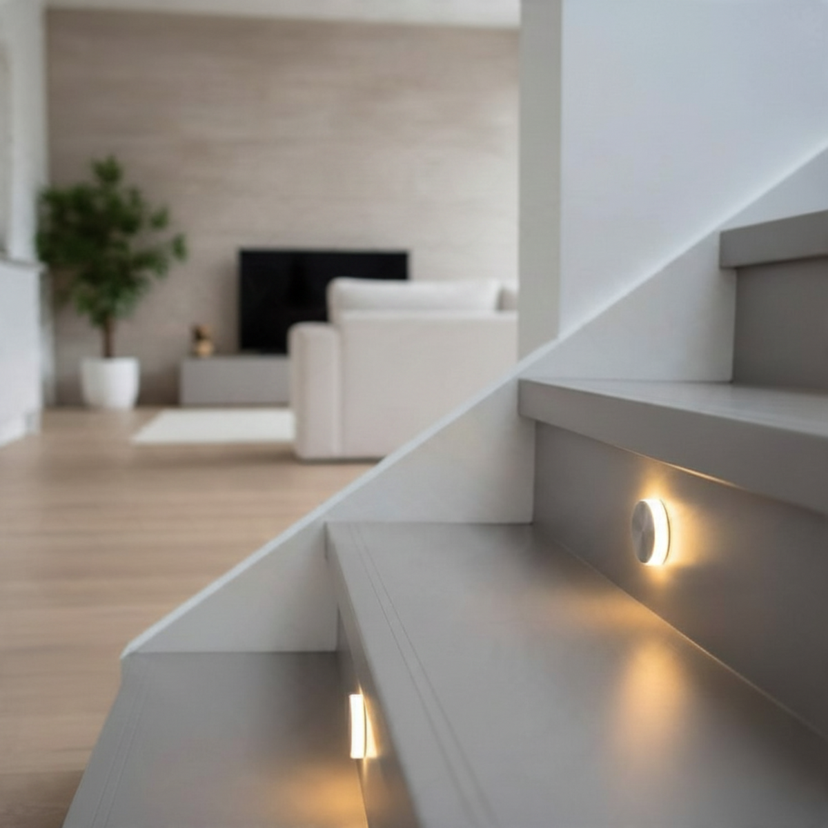 Ultra Beam Lighting Ltd round recessed LED stair light with polished aluminium finish glowing on a grey staircase