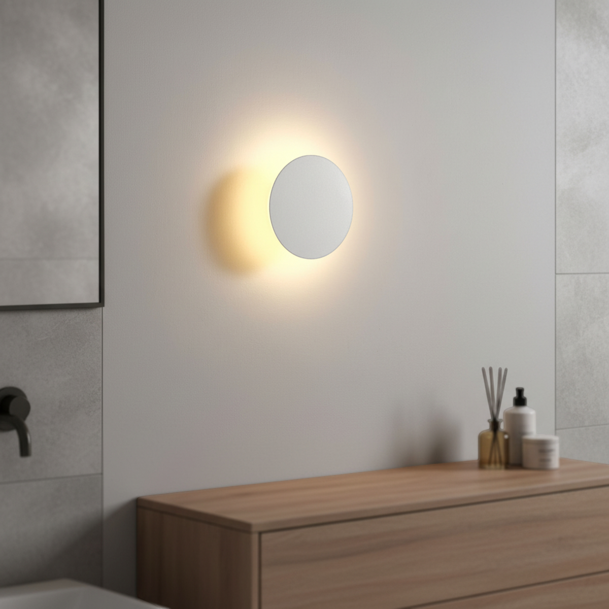Ultra Beam Lighting Ltd round white LED bathroom wall sconce creating a warm halo effect on a modern wall