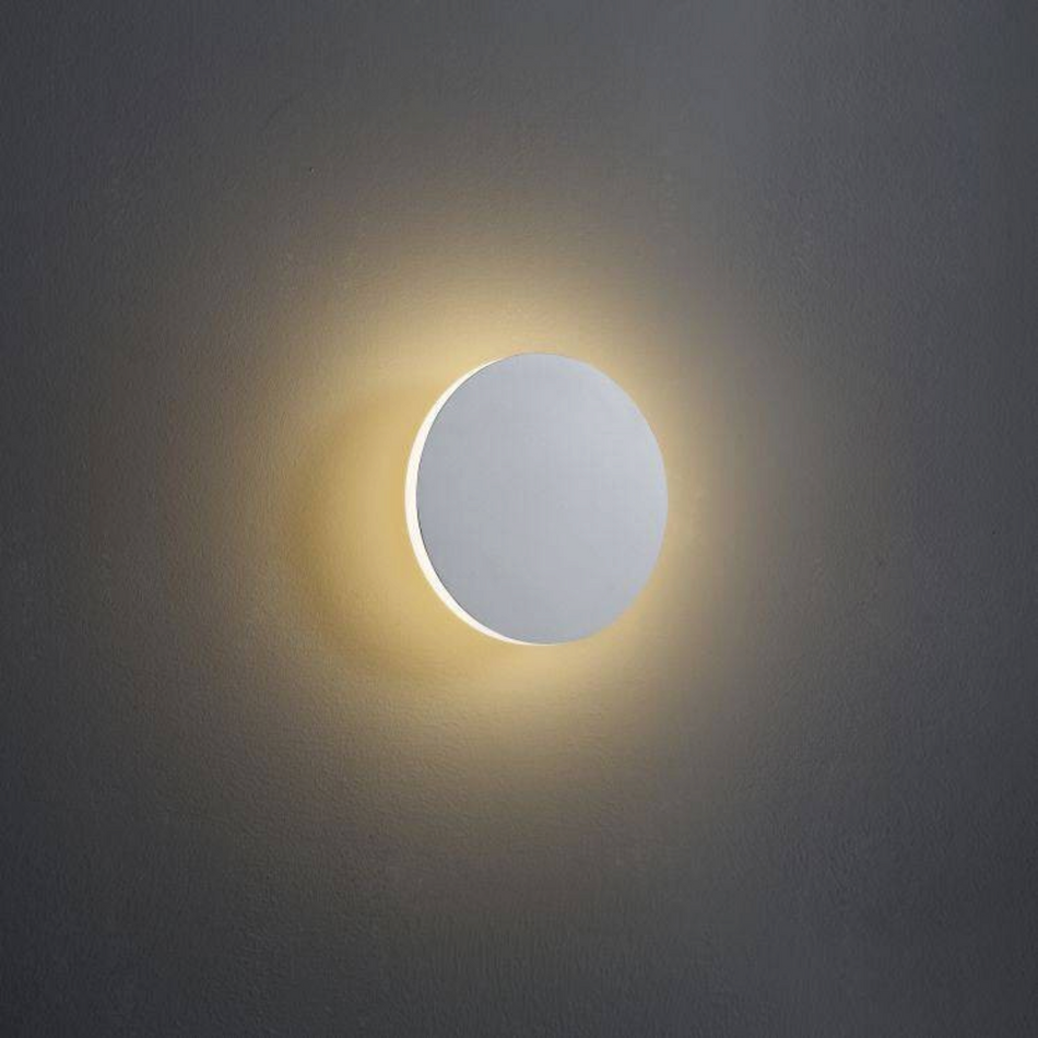 Ultra Beam Lighting Ltd round white LED wall light with a warm halo glow effect on a grey wall surface