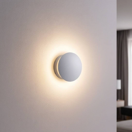 Ultra Beam Lighting Ltd round white LED wall light creating a soft glowing halo effect on a modern interior wall