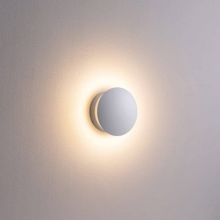 Ultra Beam Lighting Ltd round white indoor LED wall light creating a soft halo effect on a textured wall