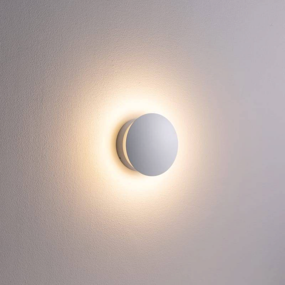 Ultra Beam Lighting Ltd round white indoor LED wall light creating a soft halo effect on a textured wall