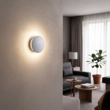 Ultra Beam Lighting Ltd round white LED wall light casting a soft halo glow on a modern living room wall