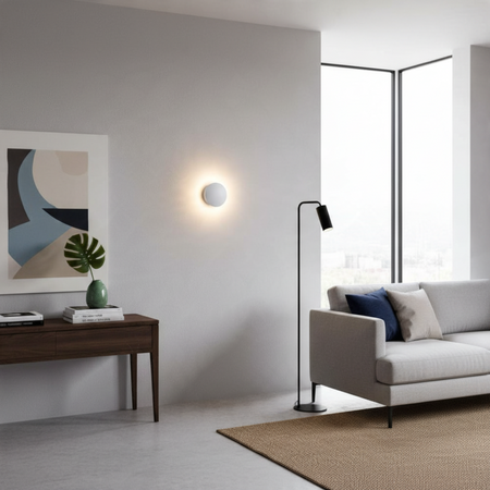Ultra Beam Lighting Ltd 6W round white LED wall light creating a soft halo effect in a modern living room interior.