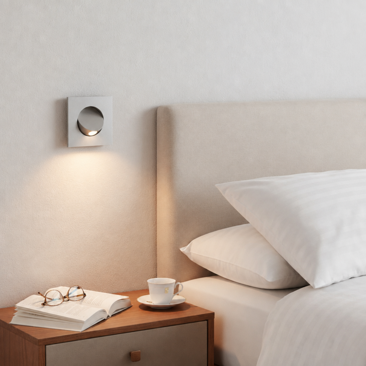 Ultra Beam Lighting Ltd square silver recessed LED reading lamp mounted on a bedroom wall above a bedside table.