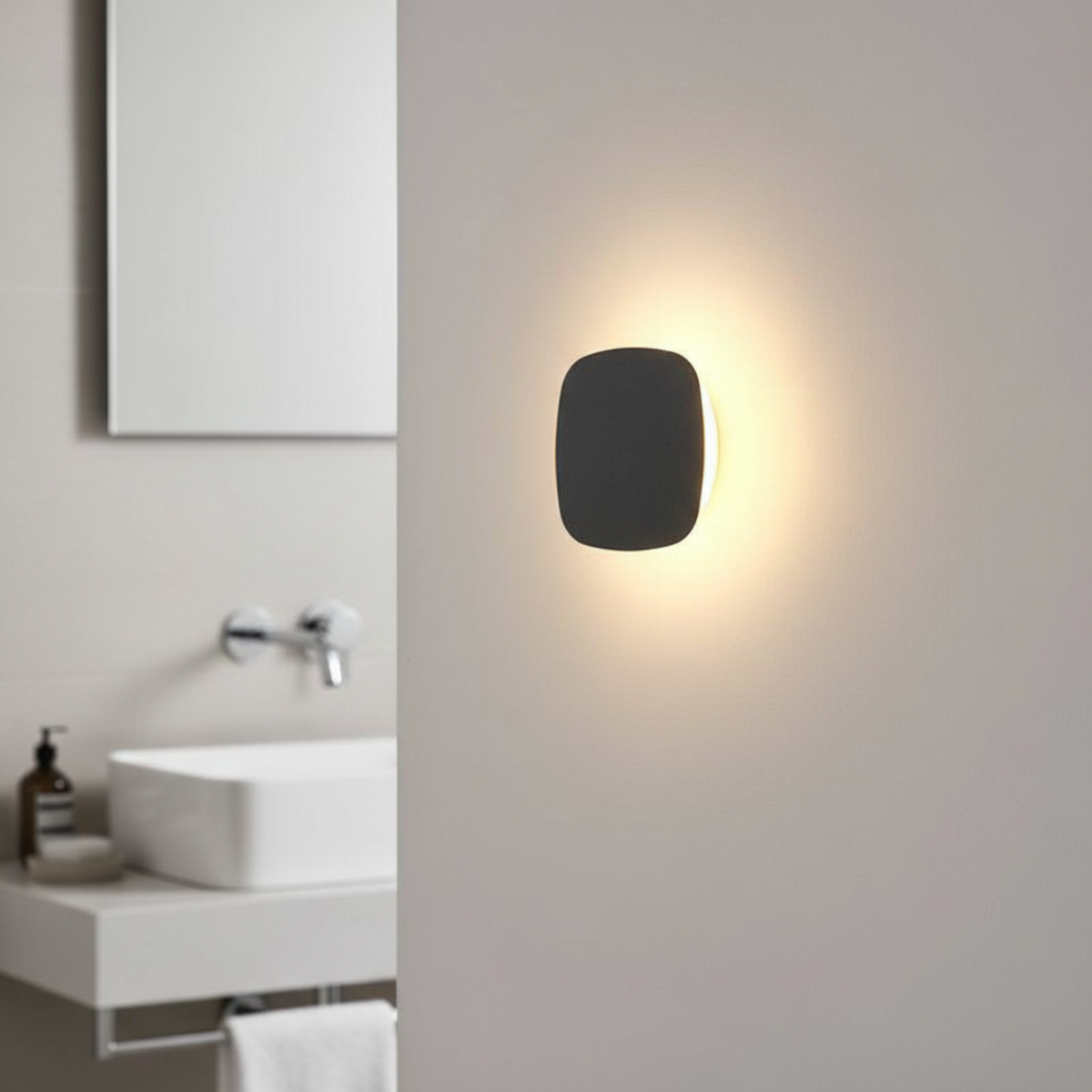 Ultra Beam Lighting Ltd square black LED vanity wall light with warm halo glow mounted on a modern bathroom wall