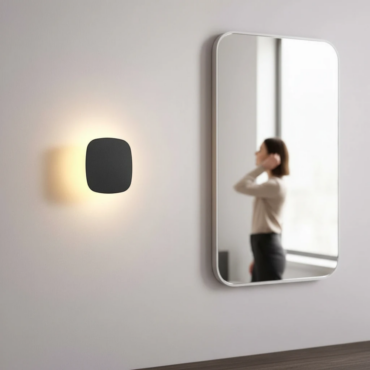 Ultra Beam Lighting Ltd square black LED vanity wall light with warm halo glow mounted next to a bathroom mirror.