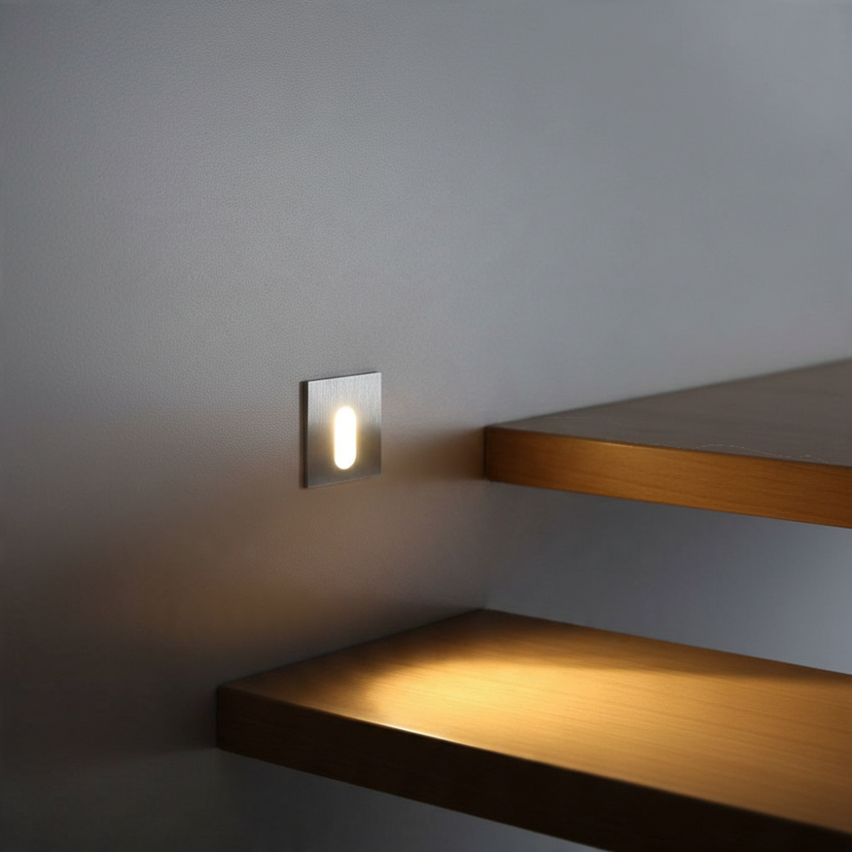 Ultra Beam Lighting Ltd square recessed LED stair light with brushed aluminum finish illuminating wooden steps