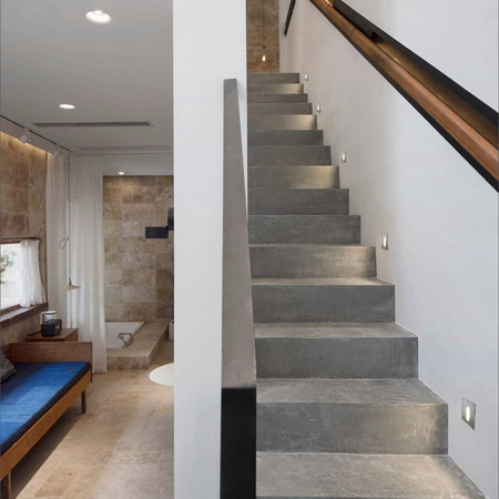 Ultra Beam Lighting Ltd square recessed LED stair lights with brushed aluminum finish illuminating a concrete staircase