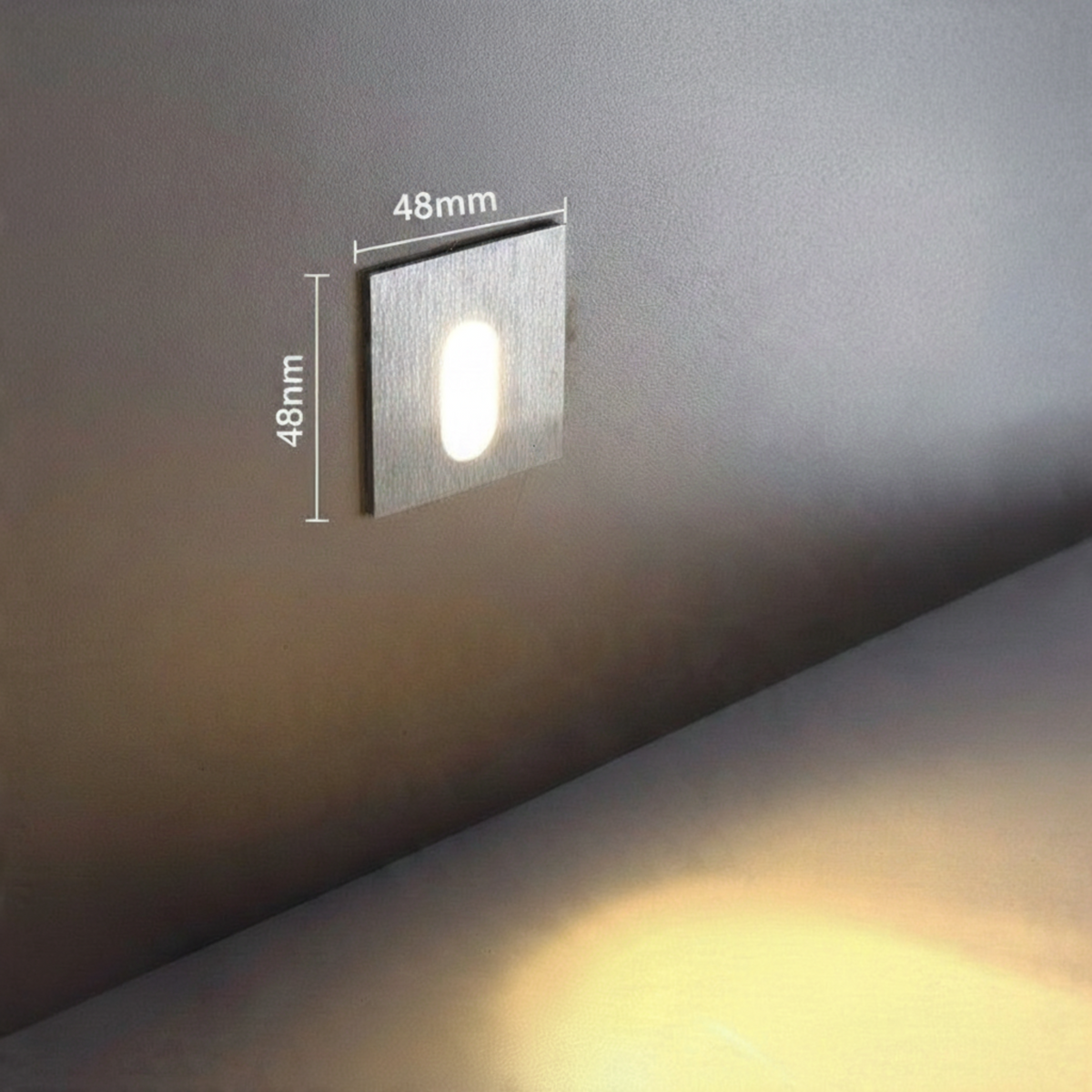 Ultra Beam Lighting Ltd square recessed LED stair light in brushed aluminum with downward beam on a grey wall