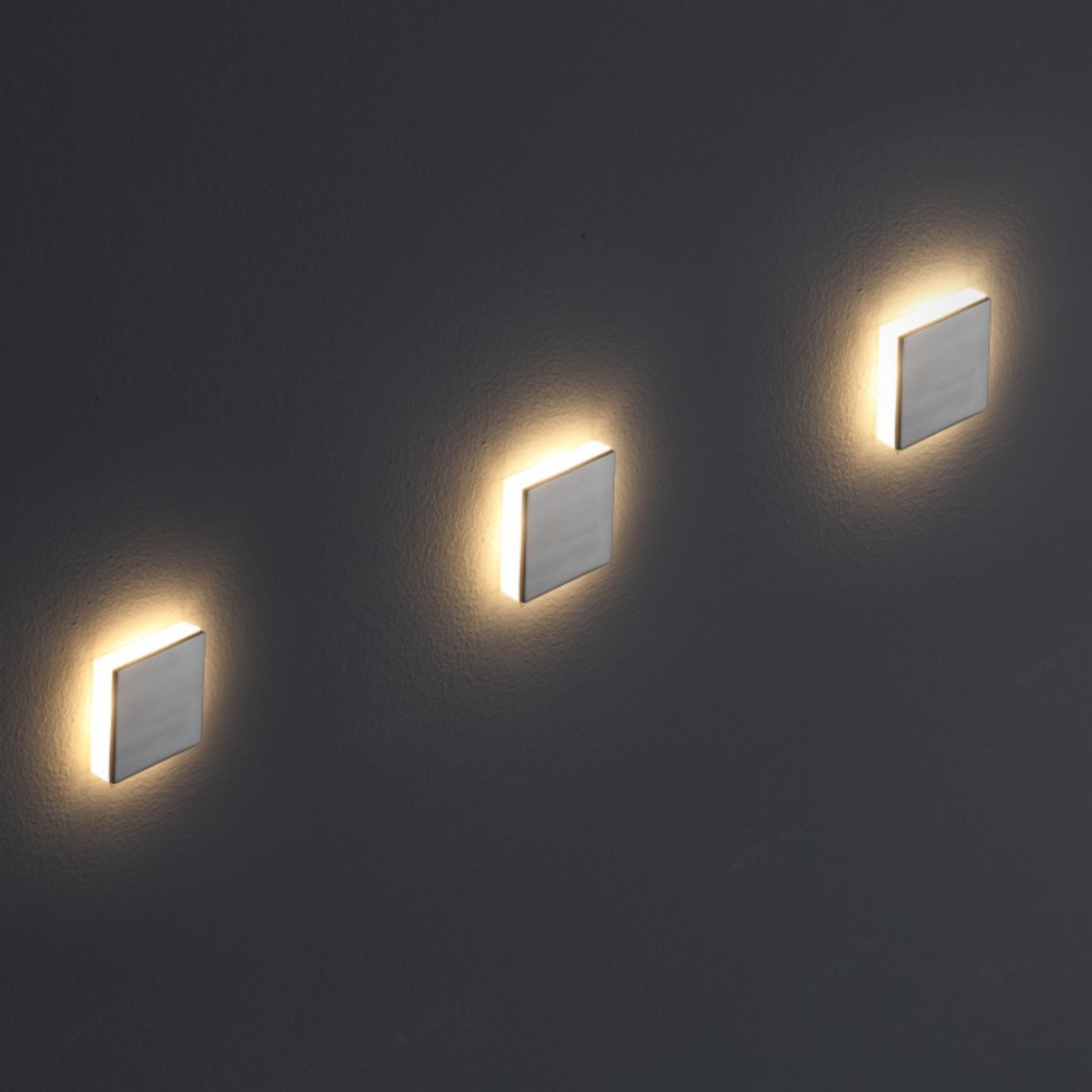Ultra Beam Lighting Ltd square recessed LED step lights with polished aluminium faceplates emitting warm ambient light.