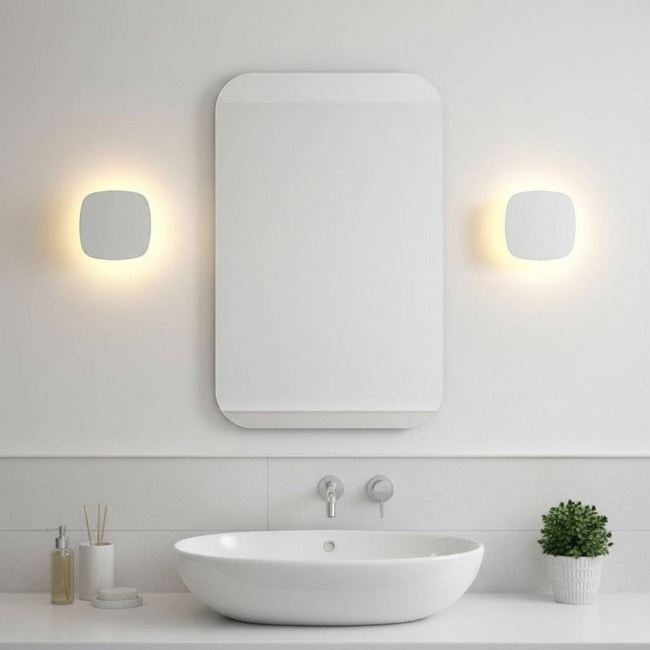 Ultra Beam Lighting Ltd square white wall-mounted LED bathroom light fixture creating a warm halo effect on the wall.
