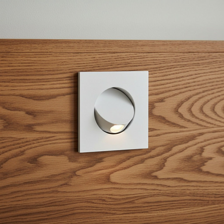 Ultra Beam Lighting Ltd square white recessed LED reading light tilted open on a wooden headboard