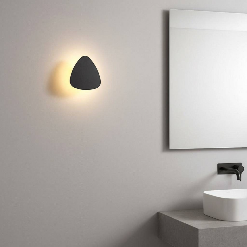 Ultra Beam Lighting Ltd triangular black LED bathroom sconce with warm white wall-washing light effect.