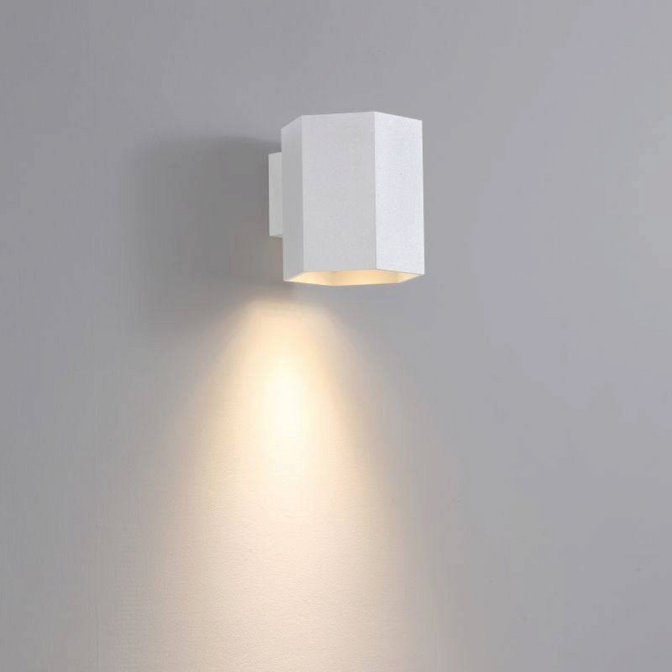 Ultra Beam Lighting Ltd white hexagonal LED wall downlight casting a warm, focused beam on a grey interior wall.