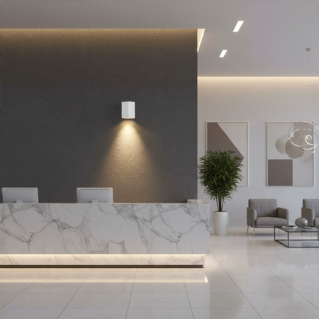 Ultra Beam Lighting Ltd white hexagonal LED wall downlight casting a warm downward beam on a modern office wall.