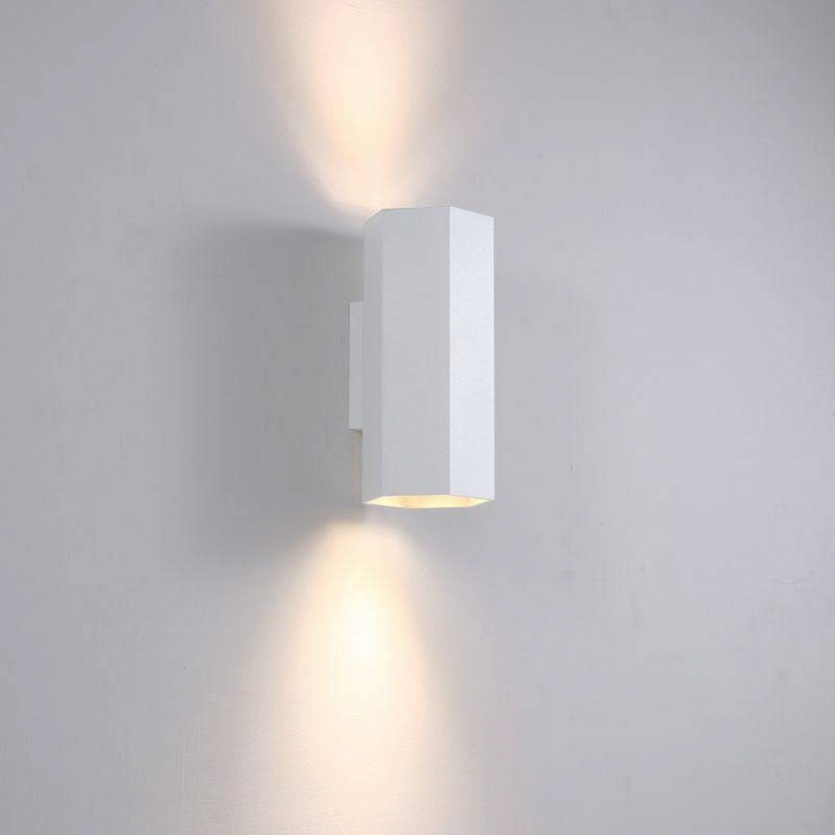Ultra Beam Lighting Ltd white hexagonal LED wall light casting warm up and down light beams on a wall