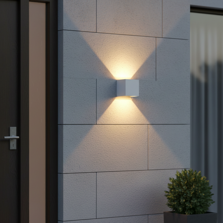 Ultra Beam Lighting Ltd white 6W LED up and down outdoor wall light casting a warm glow on a modern exterior stone wall
