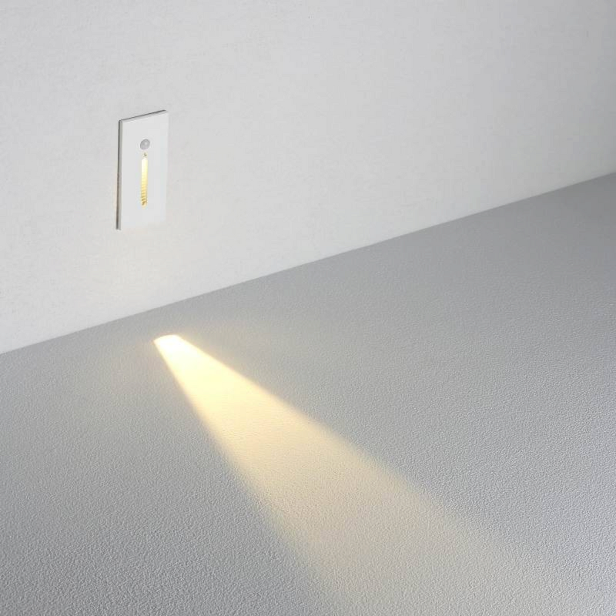 Ultra Beam Lighting Ltd white 3W LED recessed motion sensor step light casting a warm glow on a grey floor