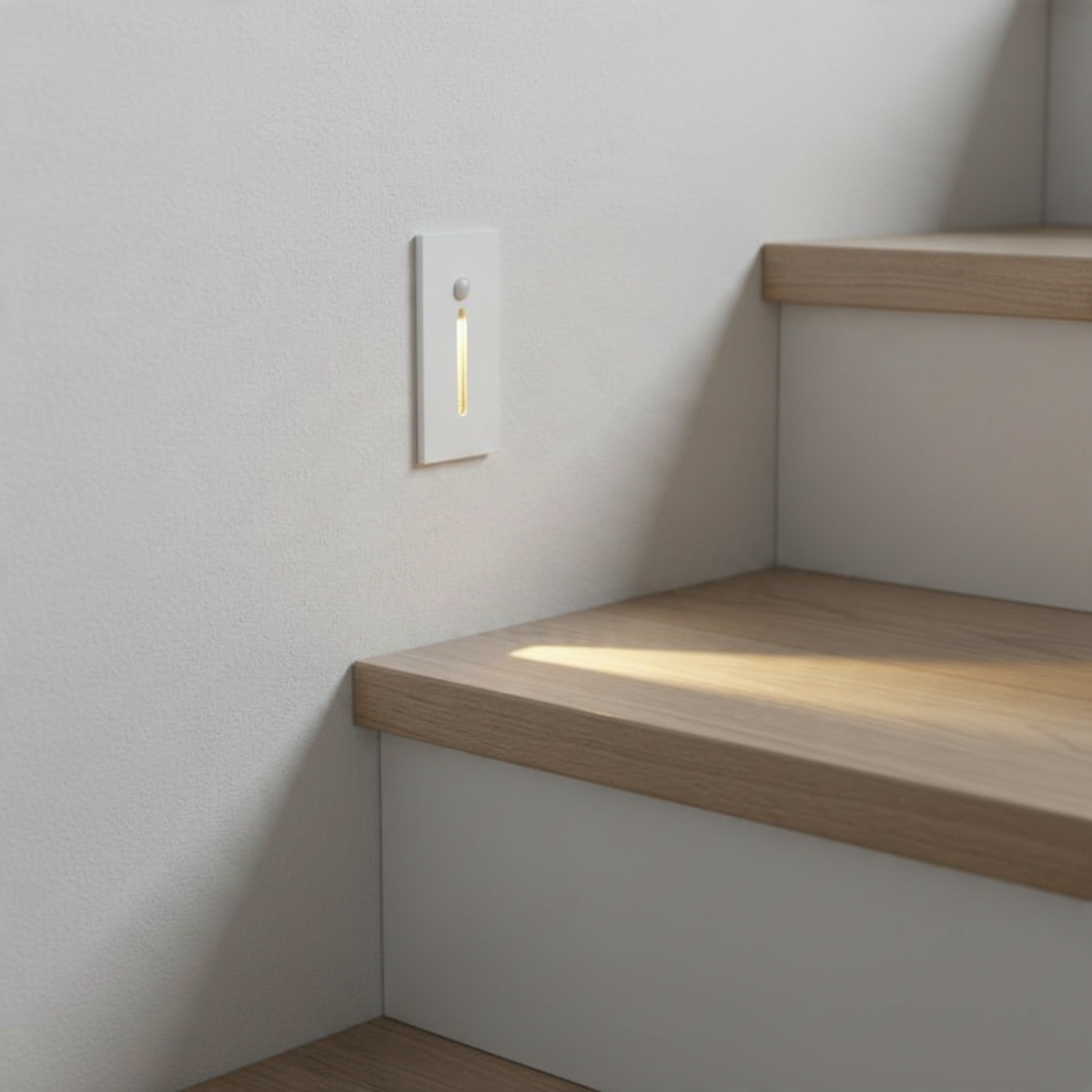 Ultra Beam Lighting Ltd white recessed LED step light with motion sensor installed on a staircase wall