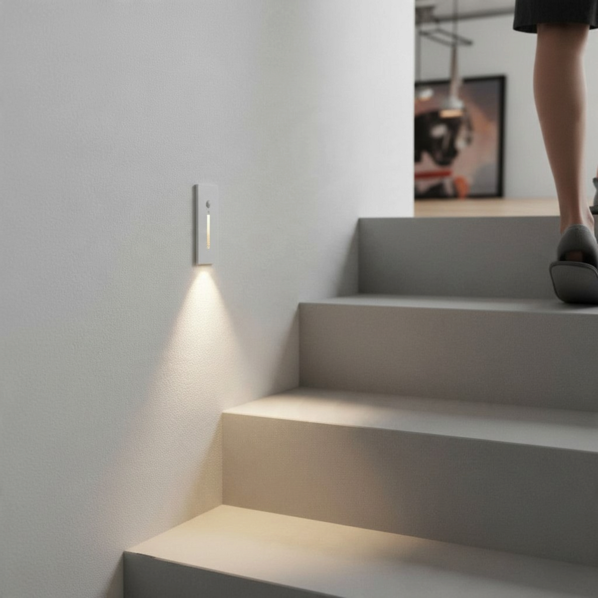 Ultra Beam Lighting Ltd white recessed LED motion sensor step light illuminating a staircase in a modern interior.