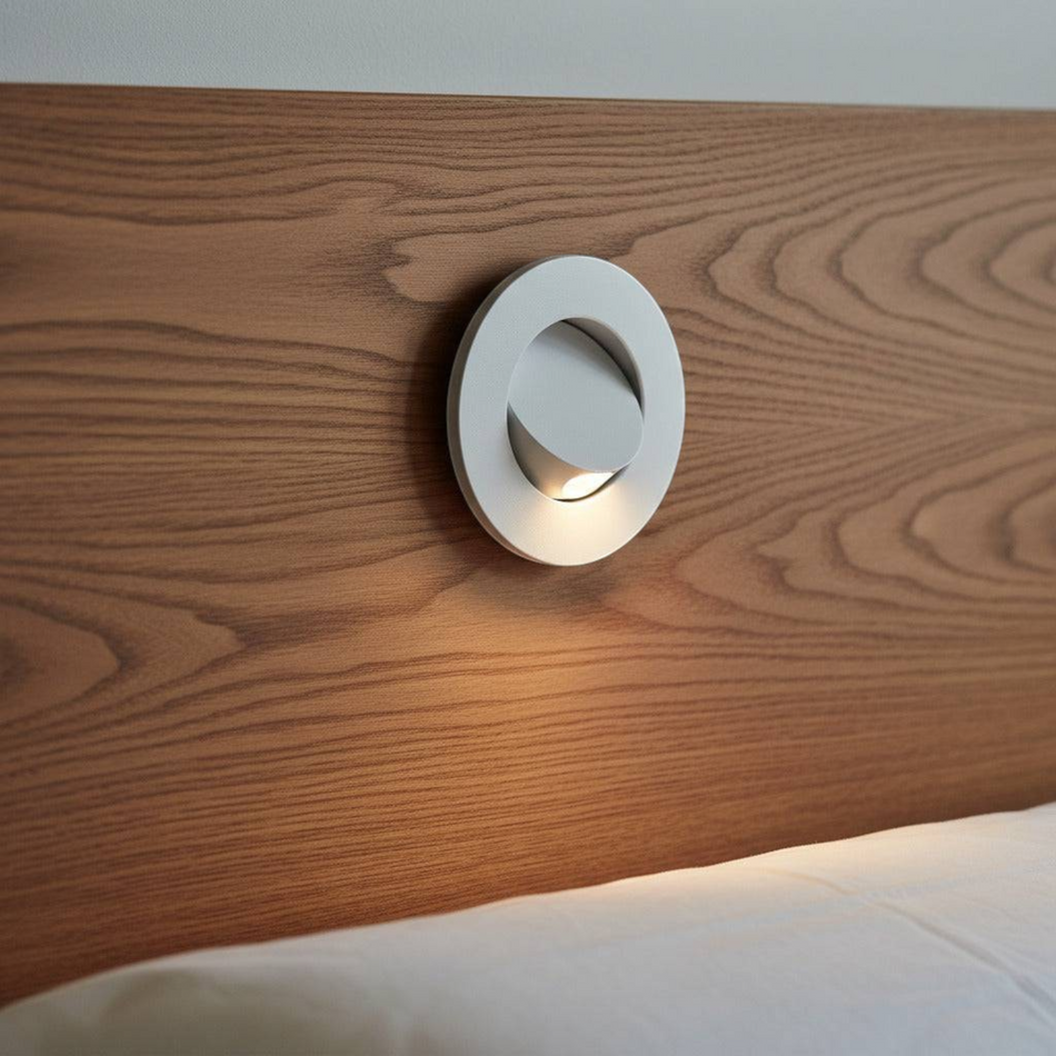 Ultra Beam Lighting Ltd white round recessed LED reading light installed in a wooden headboard with tilt switch